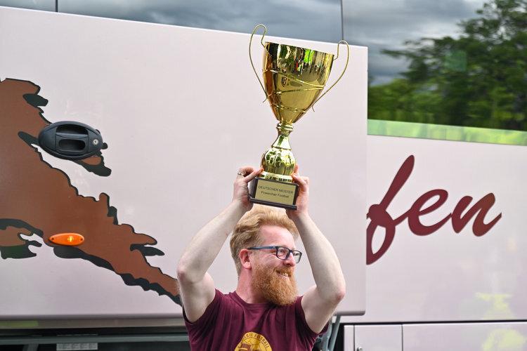 Trainer mit Meister-Pokal